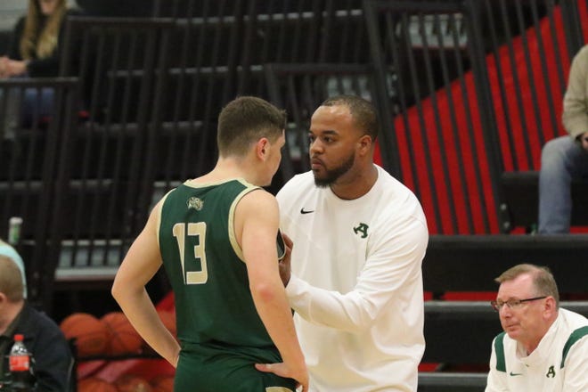Alma boys basketball coach Dominic Lincoln speaks with senior guard Stewart George during a recent game.