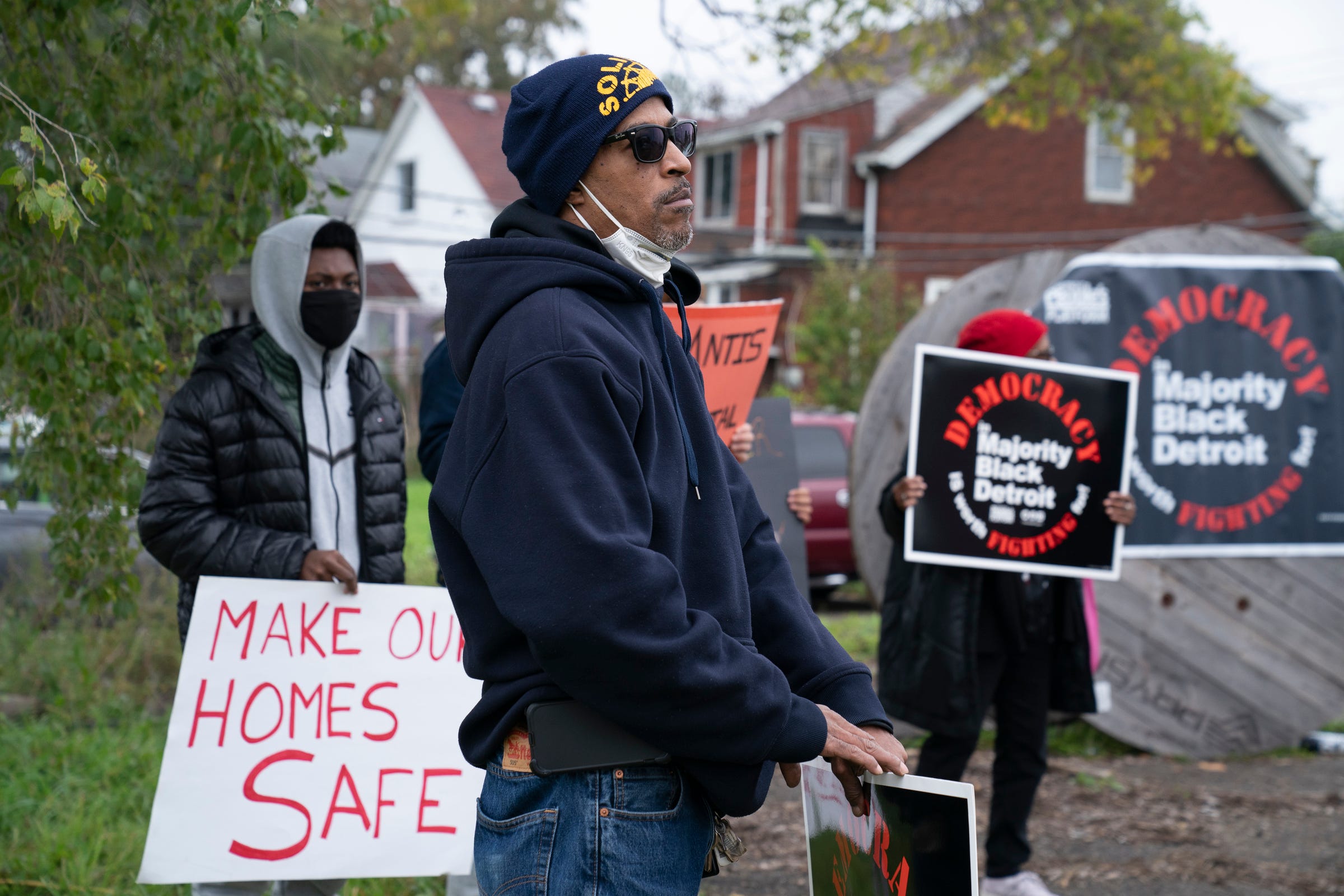 Robert Shobe, 59, holds a sign with neighbors calling themselves "Justice for Beniteau Residents" during a protest over concerns from the Chrysler Jeep Stellantis Mack Assembly Plant on Wednesday, Oct. 27, 2021.