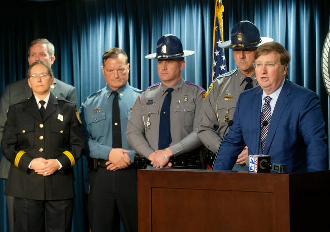 Mississippi Gov. Tate Reeves, right, expresses his gratitude for law enforcement during a press conference at the Walter Sillers State Office Building in Jackson, Miss., Monday, Dec. 20, 2021. Reeves held the press conference to recognize the sacrifices of state law enforcement officers during COVID-19.