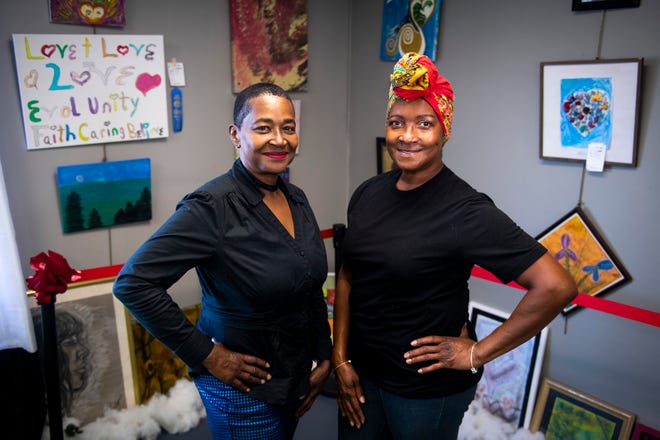 Canvas Can Do Miracles executive director Jackie Holloway, left, and program director Audrey Wallace, right, are photographed among the art displayed inside the building located at 1218 Magnolia Avenue in Knoxville on Monday, Dec.  13, 2021. 