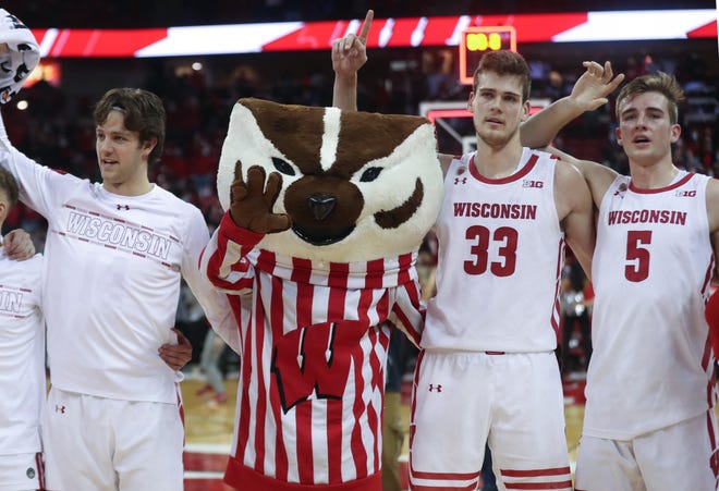 Wisconsin Badgers mascot Bucky Badger sings "Varsity" with Wisconsin Badgers center Chris Vogt (33) and Wisconsin Badgers forward Tyler Wahl (5) at the Kohl Center on Dec. 8, 2021.