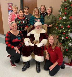 Senior-Junior Forum members recently helped out at The Kitchen’s Christmas lunch: kneeling, Traci Poore, Santa Claus and Lanell Kruger; middle row, Mary Aranda,  Ladell Schmalzried and Annette Barfield; and back row, Loisanne  Neal, Debbie Moody and Colleen James.