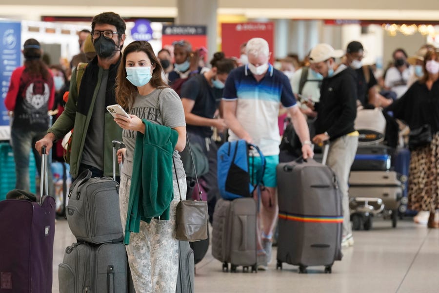 Travelers wait to check into an Air France flight in Miami. Public health officials urge caution as the new omicron COVID-19 variant has become the most dominant strain in the USA.