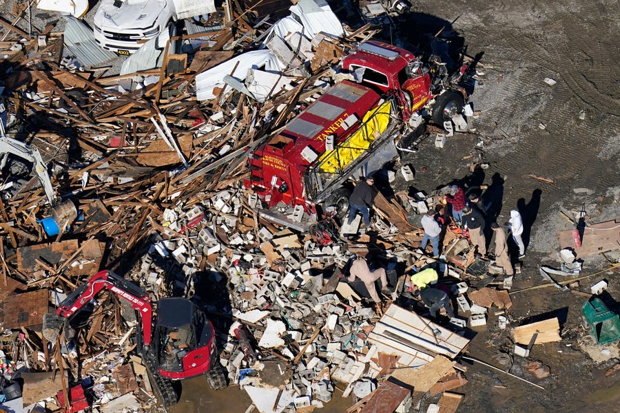 In this aerial photo, responders work through rubble next to a heavily damaged fire and rescue vehicle in the aftermath of tornadoes that tore through the region, in Mayfield, Ky., Sunday, Dec. 12, 2021. (AP Photo/Gerald Herbert) ORG XMIT: KYGH120