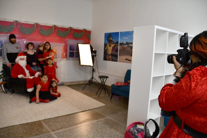 Pictures with Santa were offered at In Progress Studio 110 in downtown Crookston Sunday along with cookies, a hot cocoa bar, apple cider, coffee, candy canes and fun activities for kids. Here, the photographer lines up her shot with the Austreng family.