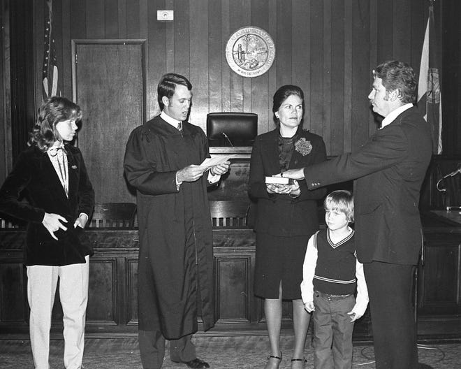 Flagler County Sheriff Dan Bennett takes the oath of office with Judge Kim Hammond in January 1981. His swearing-in is witnessed by his wife, Nancy, his daughter, Lisa, and his son, Todd.