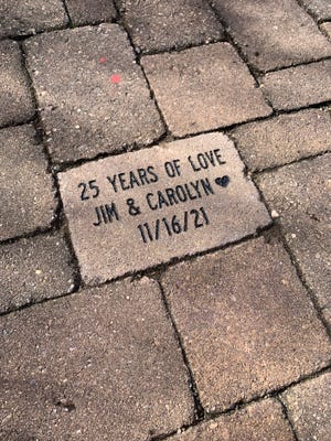 Friends of the Arboretum president Carolyn Thomas commemorates an anniversary with engraved paver bricks.