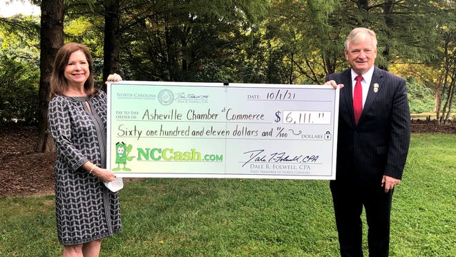North Carolina State Treasurer Dale Folwell presents a check from the unclaimed property fund to the Asheville Chamber of Commerce.