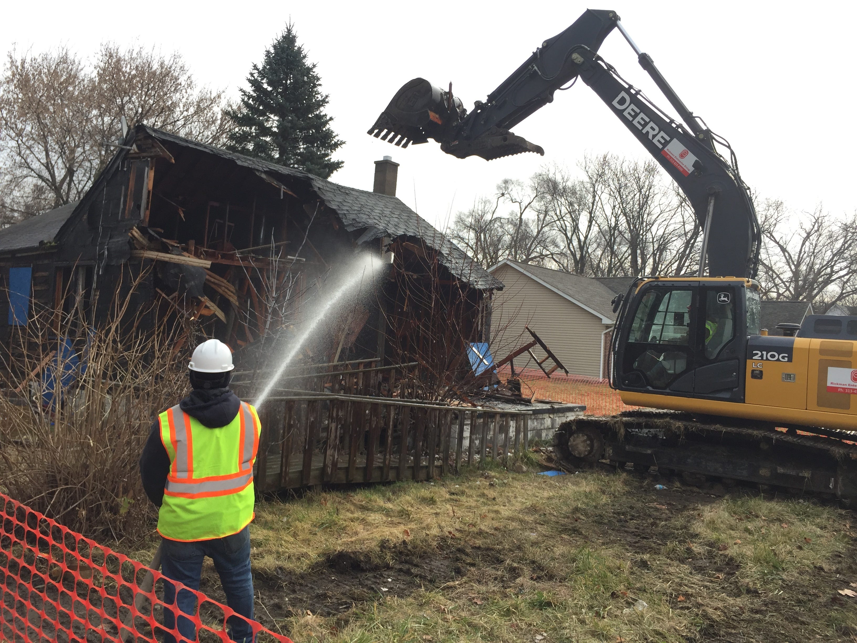 Crews tear down a blighted home behind Gompers Elementary-Middle School in Detroit's Brightmoor neighborhood on Dec. 10, 2015.