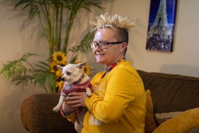 Dawn Baldwin poses with her dog at home, on Tuesday, Dec. 21, 2021, in Lafayette.