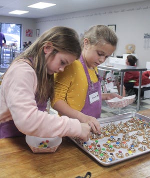 Avery Salter, 8, and Elizabeth McInnish, 8, participate in an edible Christmas gift cooking class at Pensacola Cooks on Tuesday.