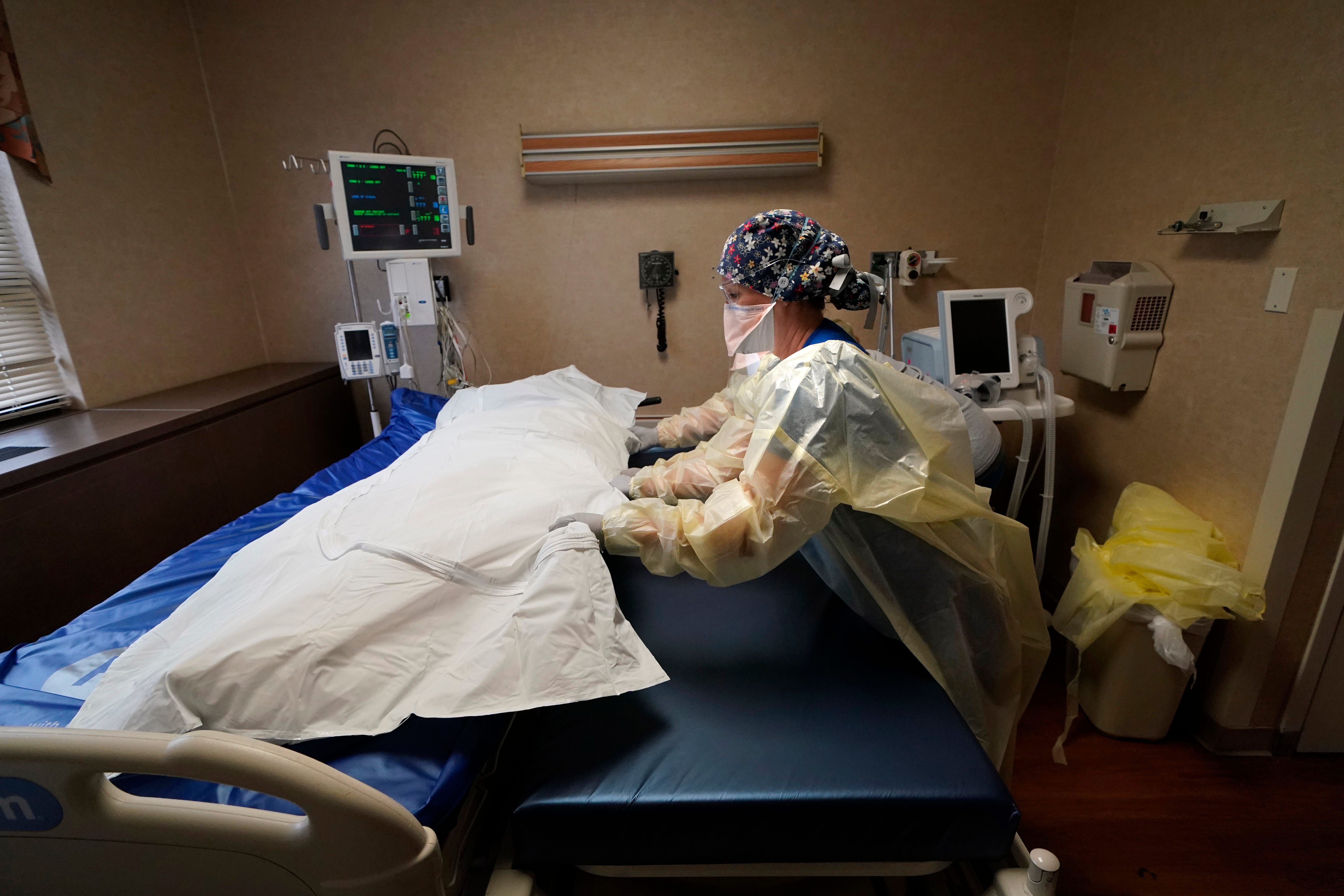 Medical staff move a COVID-19 patient who died onto a gurney to hand off to a funeral home van at the Willis-Knighton Medical Center in Shreveport, La., on Aug. 18.