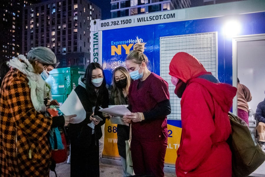 People check their rapid coronavirus test results outside a testing site on the Lower East Side of Manhattan in New York.