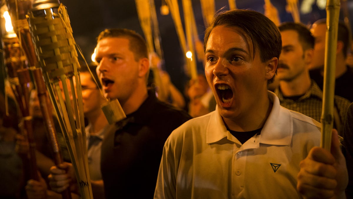 Peter Cvjetanovic (R) along with Neo Nazis, Alt-Right, and White Supremacists encircle and chant at counter protestors at the base of a statue of Thomas Jefferson after marching through the University of Virginia campus with torches in Charlottesville, Va.,  on Aug. 11, 2017.
