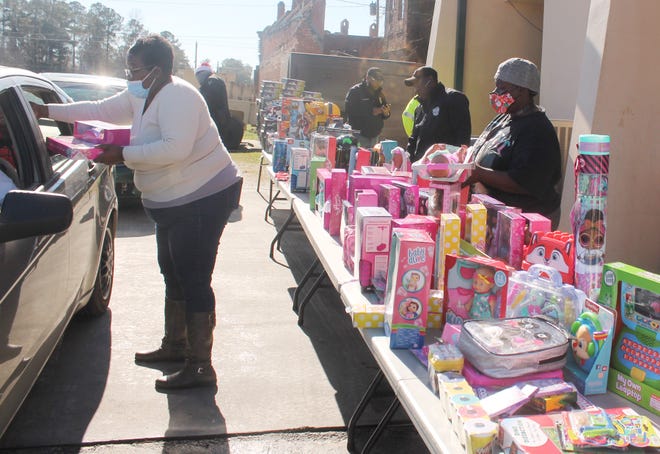 Wadley Police Department staff hand toys to parents who need help providing for Christmas.