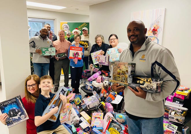 Gonzales Police Chief Sherman Jackson and Gonzales Middle School Principal Lori Charlet are shown with co-workers and toy donations.