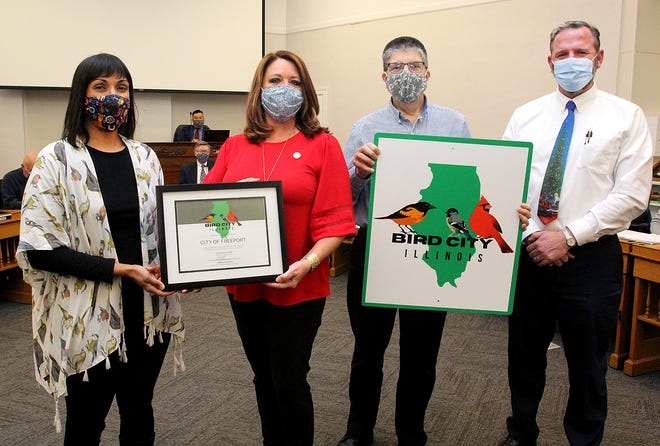 Juliet Moderow, from left, Jodi Miller, Gary Gordon, and Rob Boyer show the official certification designating Freeport as a Bird City by the Audubon Council of Illinois during a Freeport City Council meeting on Monday, Dec. 20, 2021, in Freeport.