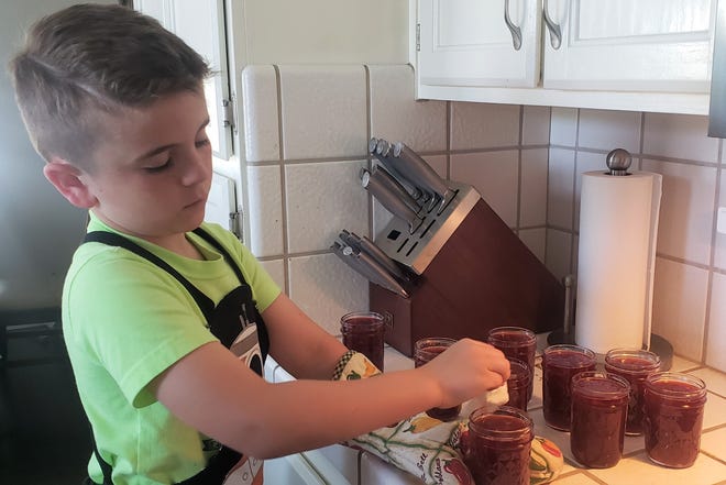 My son Andrew helping me make strawberry jelly.