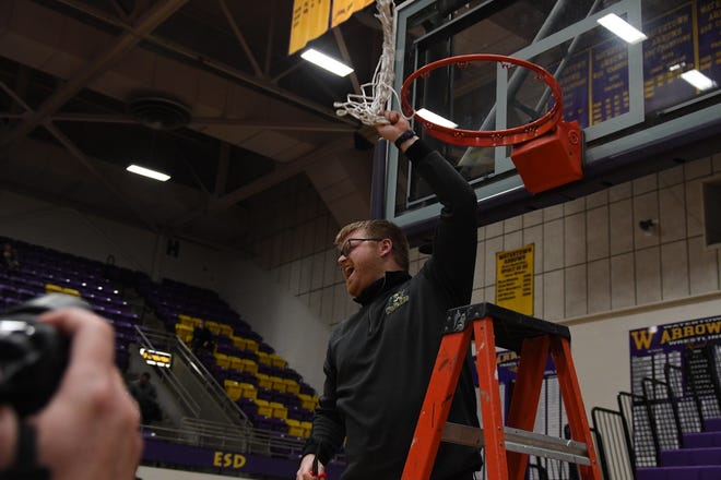Roncalli girls basketball coach Derek Laron celebrates after cutting down the nets at the 2021 Class A girls state basketball tournament in Watertown.