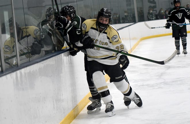 St. Paul's Chase Burdett checks Grafton's Cam Michaud into the boards during a game earlier this season.