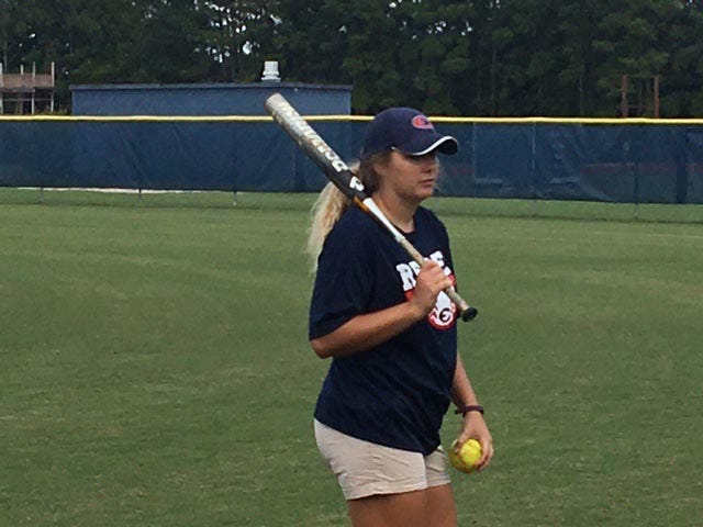 Effingham County High School softball coach Jane Trzaska hits fly balls to her outfielders during warm-ups. Trzaska recently resigned after three successful seasons. 