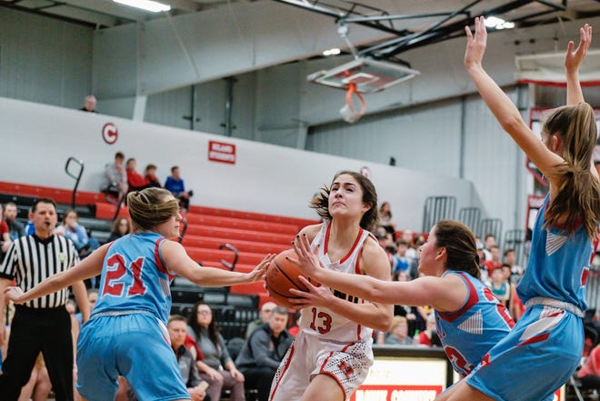 Hiland's Ashley Mullet drives to the hoop as Garaway's Marley Metzger, left and Rylee Putt, third from left attempt to block Wednesday night.