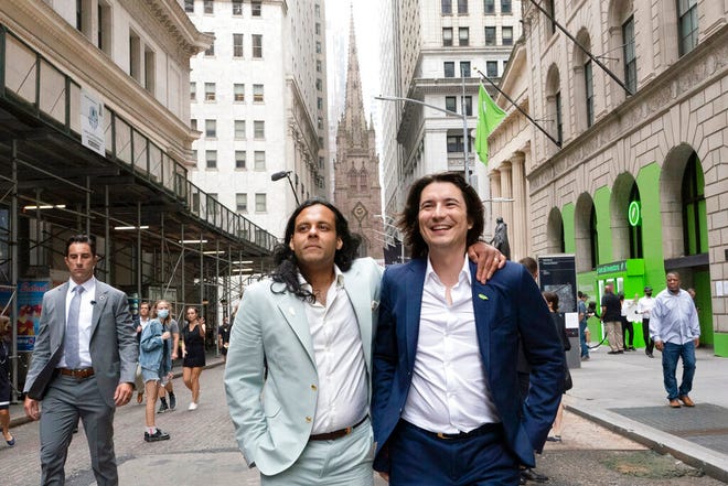 Baiju Bhatt, left, and Vladimir Tenev, Co-Founders of Robinhood, walk on Wall Street following their company's IPO at Nasdaq, on July 29, 2021 in New York.