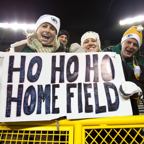 Green Bay Packers fans hold up a sign celebrating 