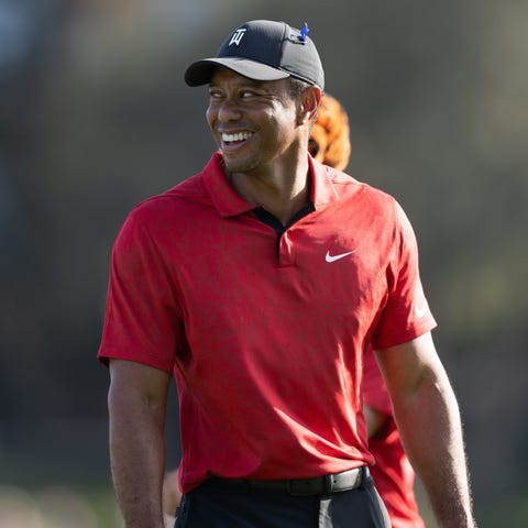 Tiger Woods smiles as he walks off the 17th green 