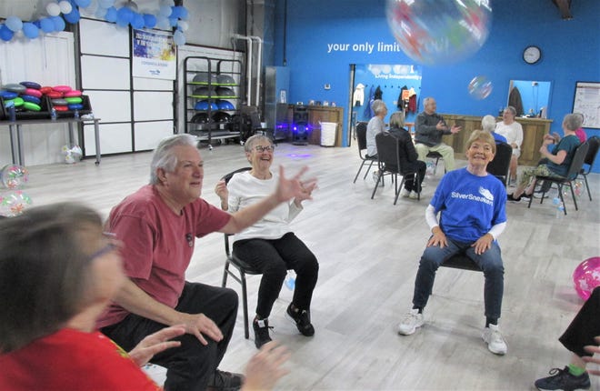 Having a ball and keeping active on Christmas Eve, a group of SilverSneakers members play a version of the game hot potato in a morning gathering at Cheyl's L.I.F.E. Fitness in Millersburg.