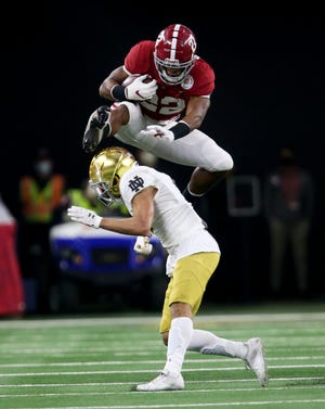 Jan 1, 2021; Arlington, TX, USA;  Alabama running back Najee Harris (22) leaps over Notre Dame cornerback Nick McCloud (4) as he makes a long run for a first down Friday, Jan. 1, 2021 in the College Football Playoff Semifinal hosted by the Rose Bowl in AT&T Stadium. Mandatory Credit: Gary Cosby-USA TODAY Sports