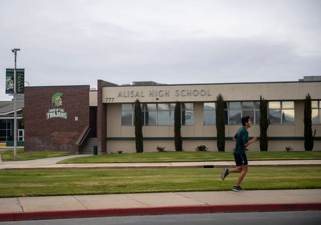 A person wearing a green shirt runs in front of Alisal High School in Salinas, California, on Thursday, March 18, 2021. Alisal High School has one of the largest student populations of all schools in the Salinas Union School District. 