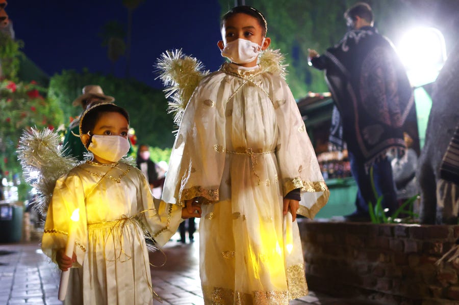 Participants dressed as angels march in the annual Las Posadas procession on historic Olvera Street, a Mexican marketplace, on December 17, 2021 in Los Angeles, California. Las Posadas was celebrated on Olvera Street every year since 1930- until last year's celebration was cancelled due to the pandemic. Las Posadas is a nine-day festival culminating on Christmas Eve which is celebrated across Mexico and in parts of the U.S. and marks Mary and Joseph's journey to Bethlehem in search of refuge.