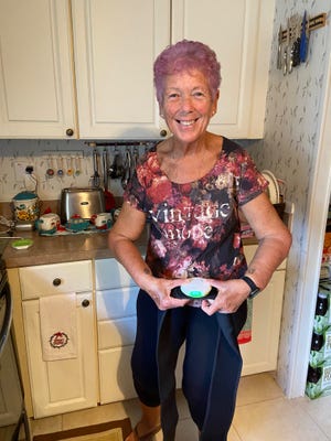 Kathy Boehm holds the wireless charging system used to recharge a small neurostimulator implant insideher body. The implant uses electrical impulses to modify nerves affecting her bladder.