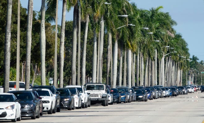 Cars line up along Palm Beach Lakes Boulevard to wind through a neighborhood and eventually get into Gaines Park for drive-thru COVID-19 testing in West Palm Beach Sunday, December 26, 2021. Traffic was also backed up on Australian Boulevard to get onto Palm Beach Lakes. PCR and rapid tests are available. Testing is free, but people should bring their insurance or Medicare/Medicaid card. 
