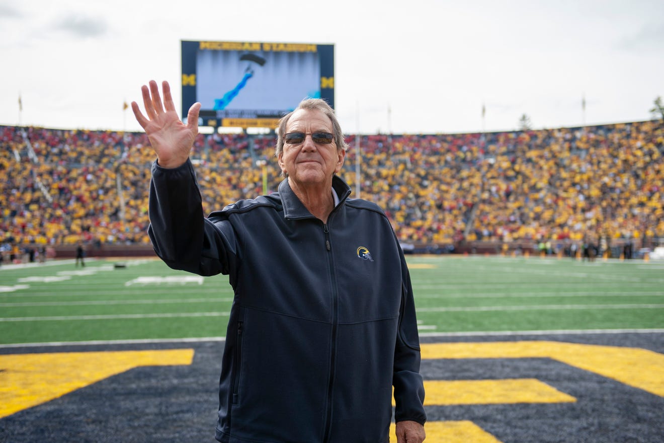 Former Michigan head football coach Lloyd Carr waves to the fans before a game in 2018.