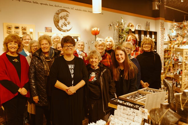 Sara Russell (front, in black) with volunteers at The Bridge in downtown Holland. Russel is retiring after 28 years as manager of the store.