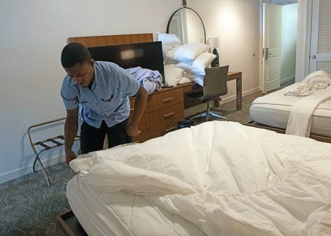 Errol Green, a Pensacola Beach Hilton's housekeeping staff member, prepares a room for new guests on Monday, Dec. 27, 2021. 