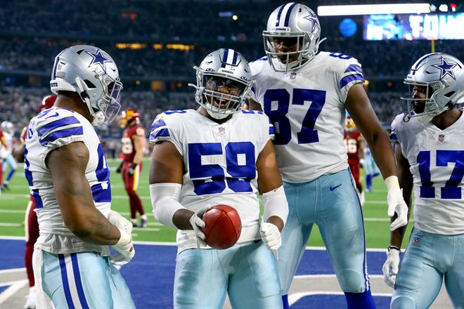 Chauncey Golston #59 of the Dallas Cowboys celebrates with teammates after recovering a blocked punt for a touchdown during the third quarter against the Washington Football Team at AT&T Stadium on December 26, 2021 in Arlington, Texas.
