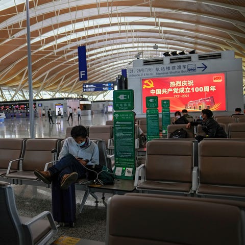 Passengers wearing face masks rest at Pudong Inter