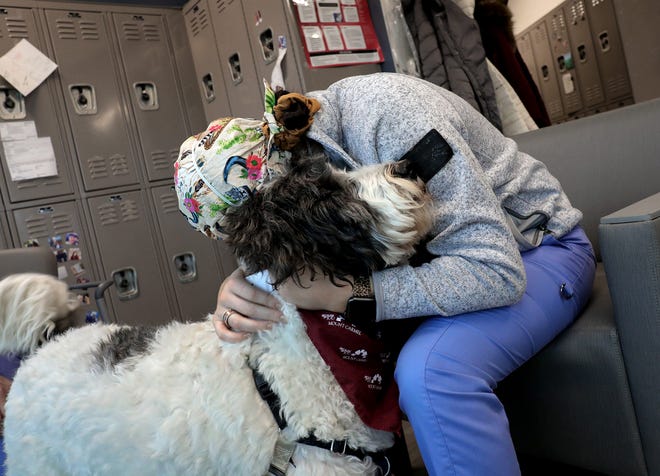 Holly Riegel, a multi-skilled patient technician, hugs Gracie in a break room after tending to COVID patients at Mount Carmel Grove City.