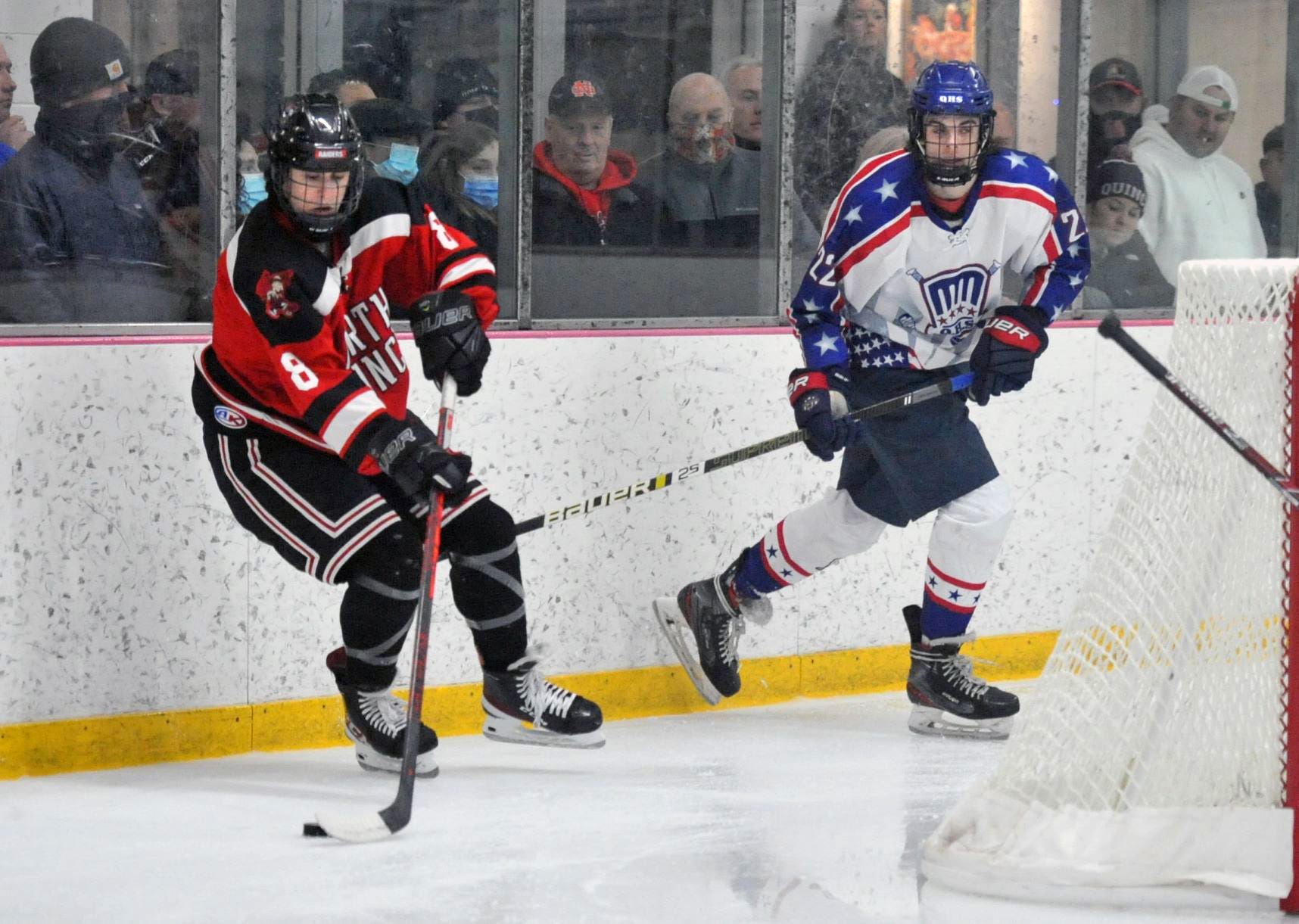 North Quincy's Brian Buckley, left, works the puck behind the net as Quincy's Pat Walsh moves in during the holiday hockey tournament at Quincy Youth Arena, Monday, Dec. 27, 2021.