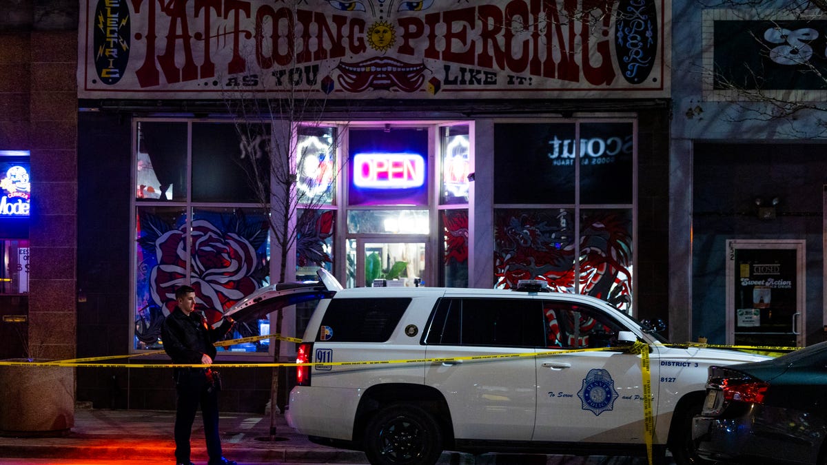 Police officers stand outside Sol Tribe tattoo shop on Broadway where two women were killed and a man was injured in a shooting on December 27, 2021 in Denver, Colorado. The Broadway shooting was the first scene in a shooting spree that killed five people across the Denver metro area.