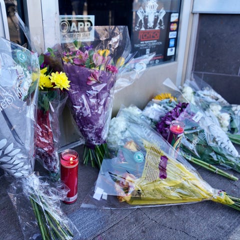 A memorial grows outside a tattoo shop in Denver o