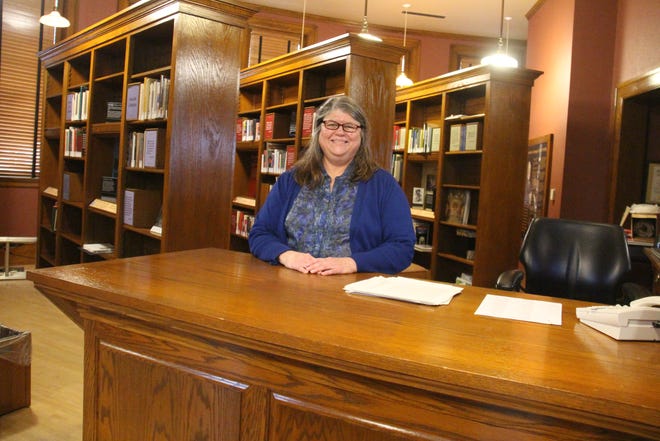 Mary Murphy, director of the Perry Public Library, stands behind the front desk at the Carnegie Library Museum. The building will reopen on Tuesday, Jan. 4 after an agreement was reached between the Perry Public Library, city of Perry and Hometown Heritage.