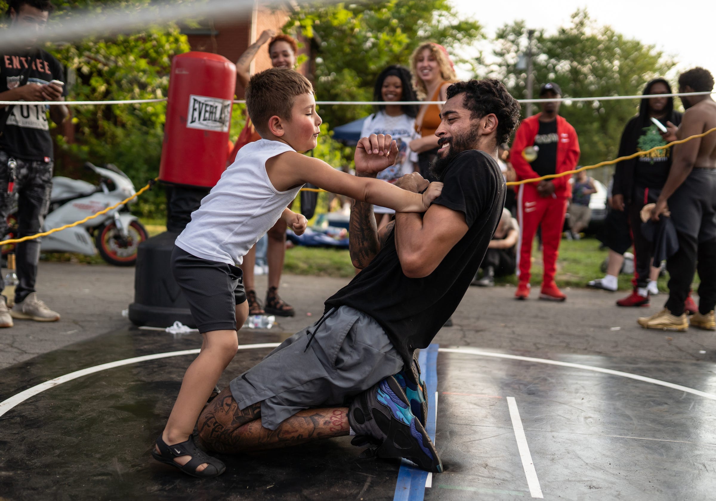 Michael Futrell Jr., who goes by Little Michael, throws a punch at Dwayne Taylor of Lincoln Park as he pretends to fight him between matches during a Pick Your Poison Detroit event put on by Taylor in Detroit's Delray neighborhood on Sunday, June 19, 2021.
