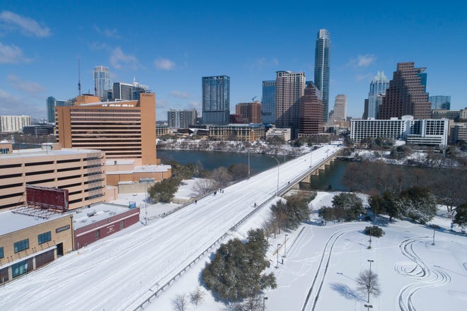 The Ann Richards Congress Avenue Bridge is devoid of traffic after a heavy snow on Monday, Feb. 15, 2021.
