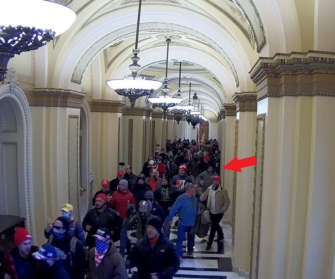 This image, included in a prosecutor's sentencing memo for First Coast resident Jeffrey Register, seems to show Register (by arrow) walking with Jan. 6 rioters down a hall moments after a man with a similar jacket waved to the crowd to join him.
