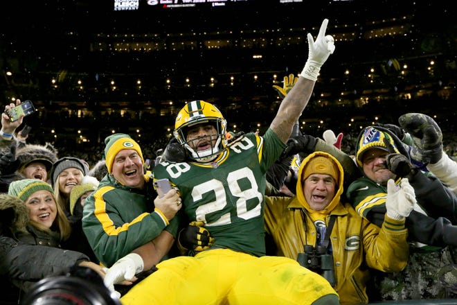 Green Bay Packers running back A.J. Dillon celebrates scoring his first of two rushing touchdowns with a Lambeau leap during a November win at Lambeau Field.