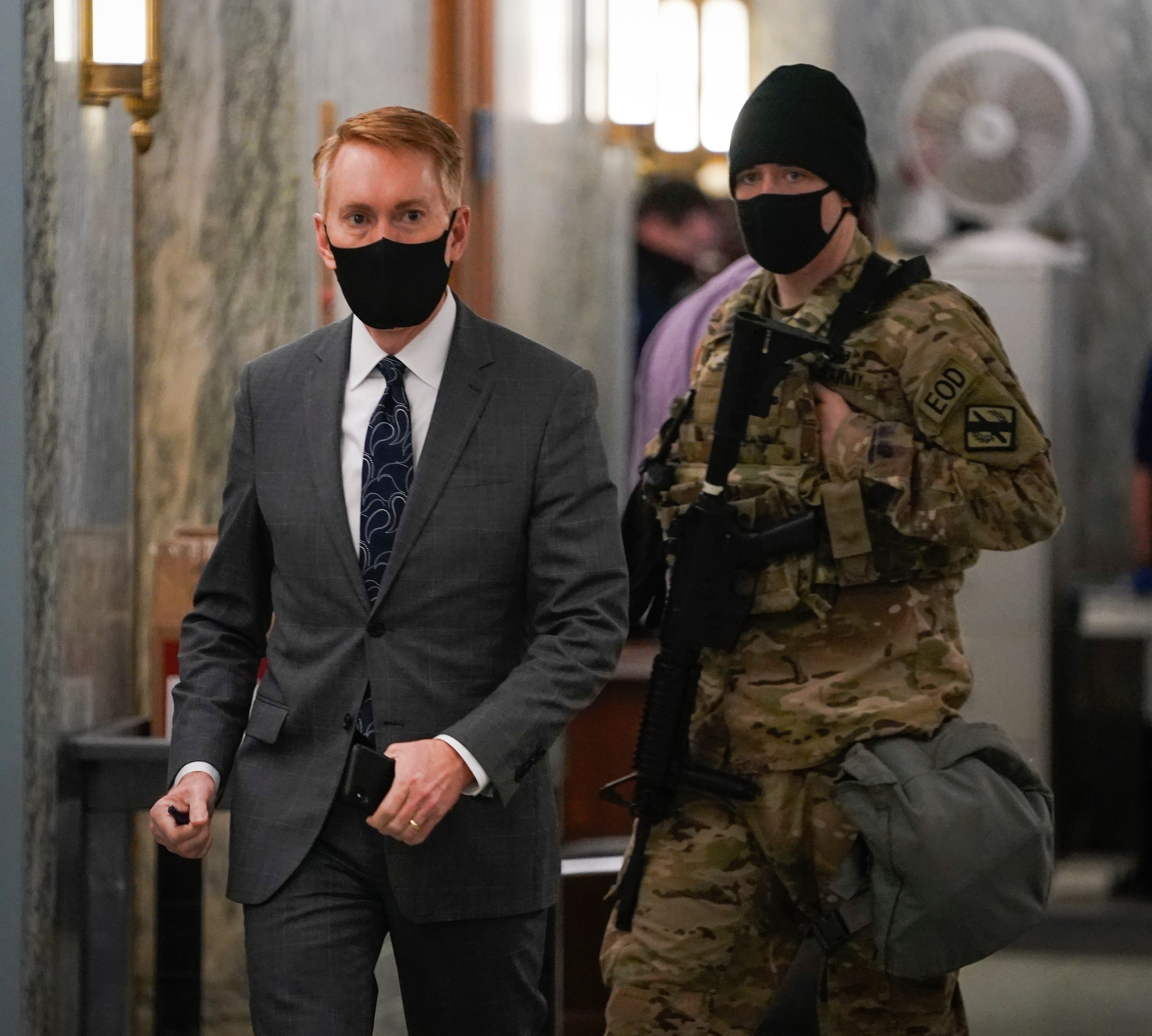 Sen. James Lankford arrives for a committee hearing on the Jan. 6 attack on the U.S. Capitol as members of the National Guard navigate and walk through the Dirksen Senate office building on Feb. 23.